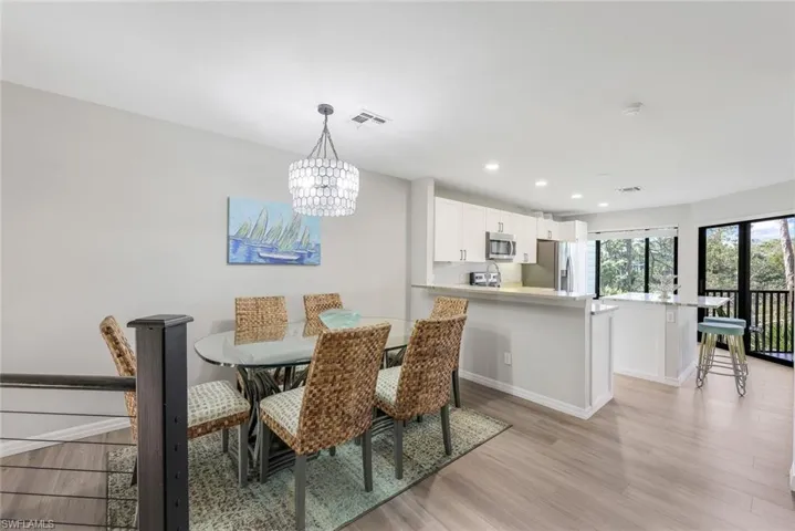 Dining area with recessed lighting, light wood-style floors, and a chandelier