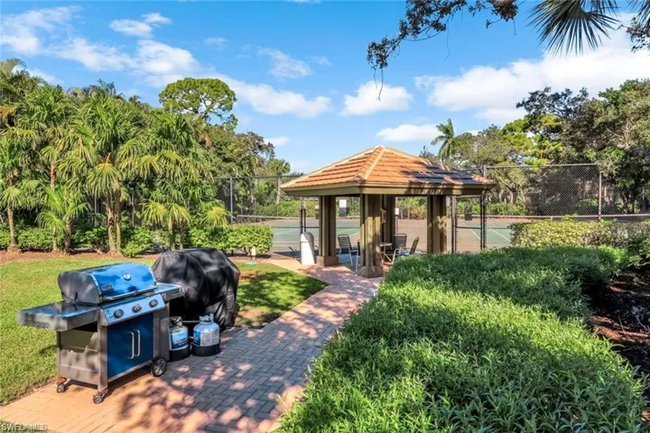 View of patio gazebo and neighborhood grilling area near tennis courts.