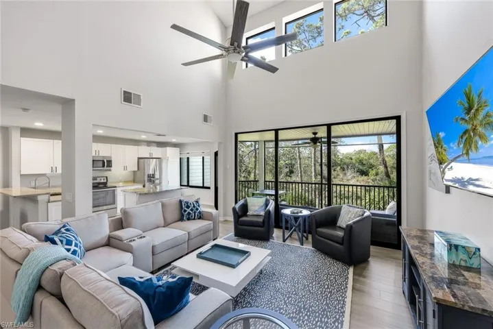 Living area with ceiling fan, light wood-style floors, and plenty of natural light