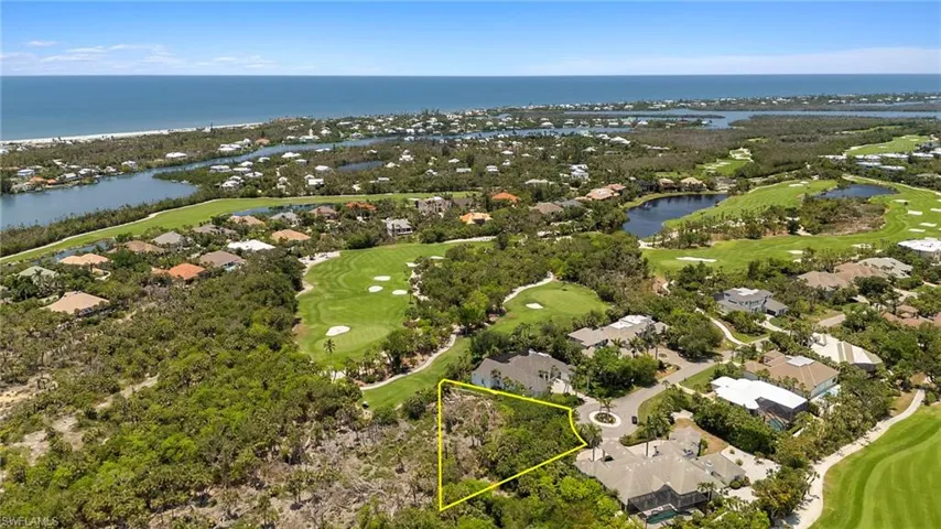 Aerial view of residential area featuring a golf club, a nearby body of water, and property boundaries highlighted