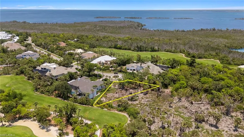 Aerial view of residential area with a golf course and a nearby body of water