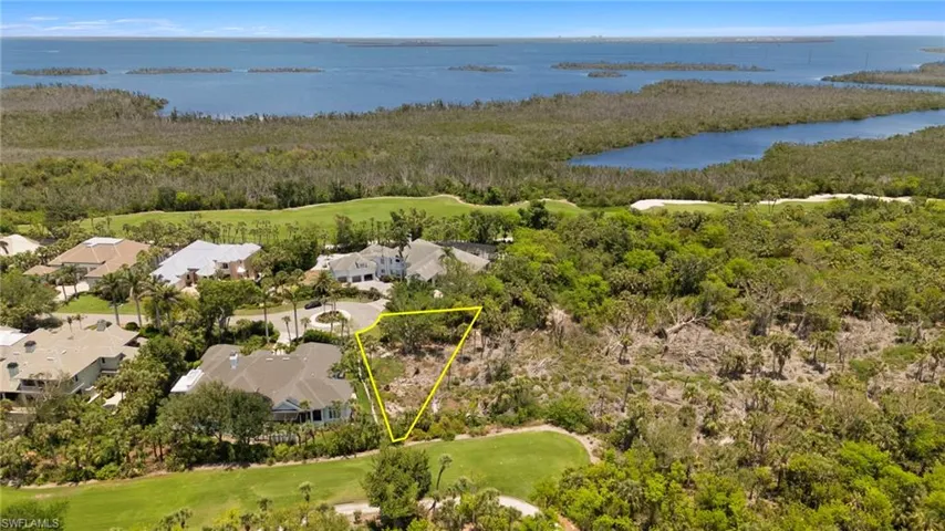 Aerial view of residential area featuring a large body of water, a golf club, and property boundaries highlighted