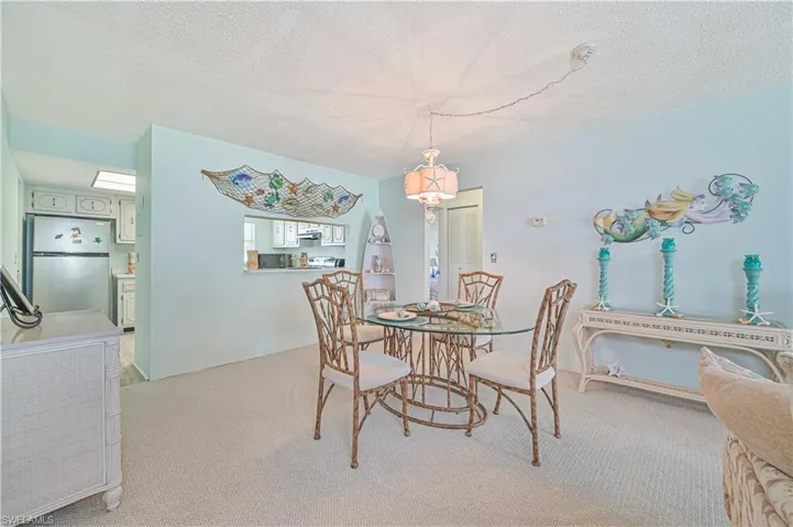 Dining space featuring light carpet and a textured ceiling