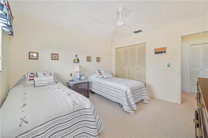 Carpeted bedroom with a textured ceiling, a closet, and ceiling fan
