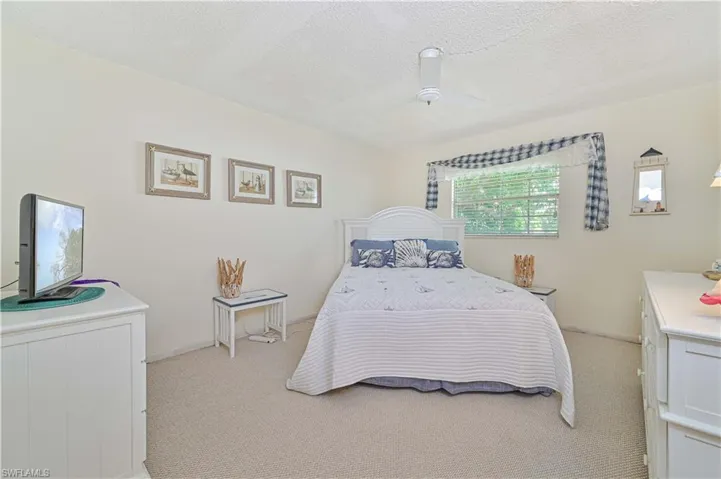 Bedroom featuring light carpet, ceiling fan, and a textured ceiling