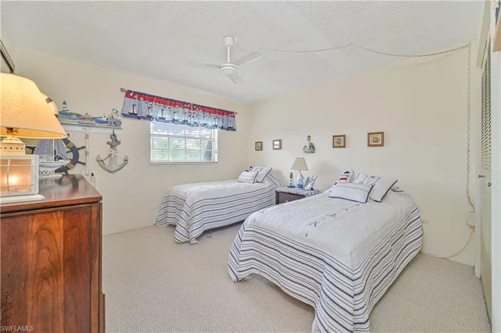 Carpeted bedroom featuring a textured ceiling and ceiling fan