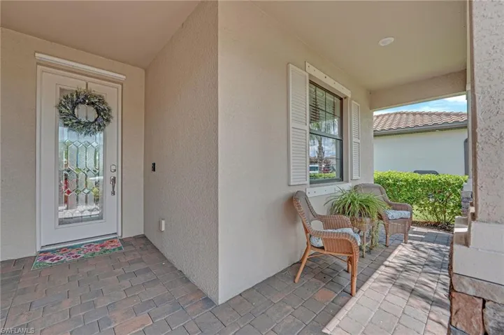 View of exterior front entry with a porch and stucco siding