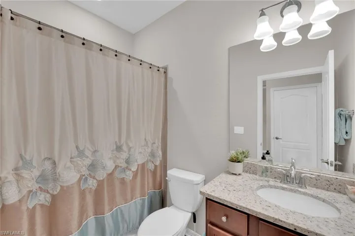 Full bath featuring vanity and a chandelier
