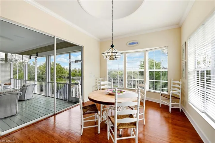 Dining area featuring ornamental molding, wood finished floors, and suspended lighting
