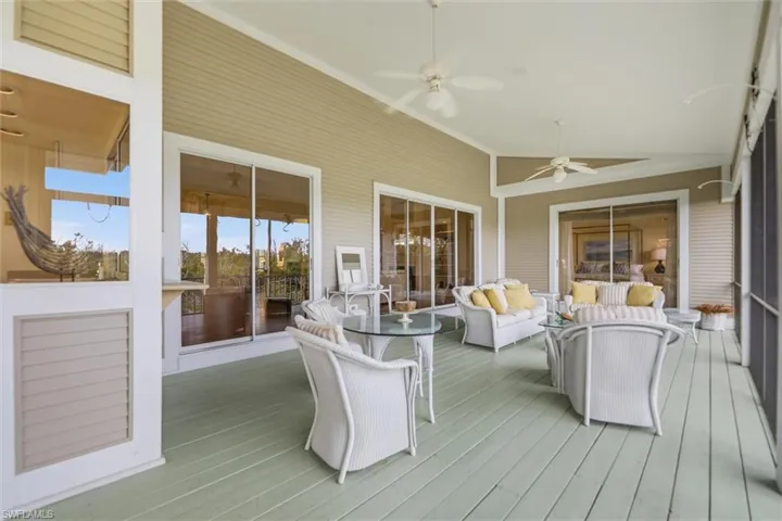 Wooden deck featuring a sunroom, outdoor furniture, and ceiling fan
