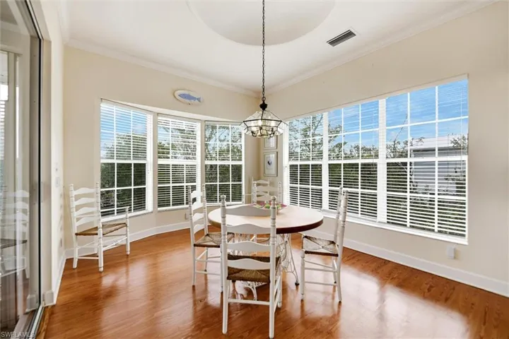 Dining area featuring crown molding, a chandelier, and light wood finished floors