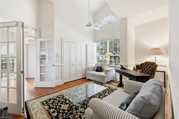 Living room featuring ceiling fan, wood finished floors, and vaulted ceiling