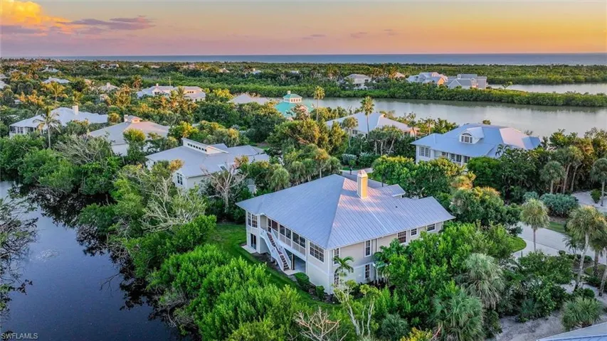 Aerial view at dusk of a water view and view of wooded area