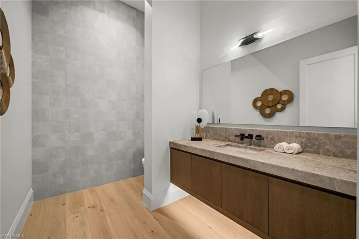 Full bath featuring wood finished floors, vanity, toilet, and baseboards