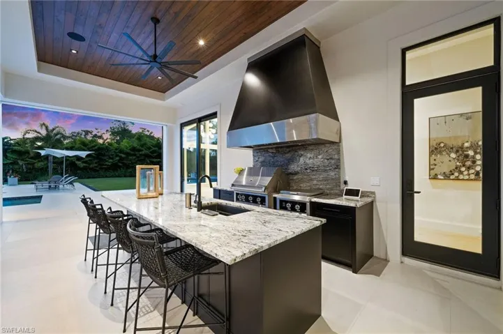 View of patio featuring exterior kitchen, area for grilling, and a ceiling fan
