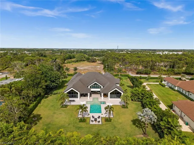 View of subject property featuring a pool and a tree filled landscape