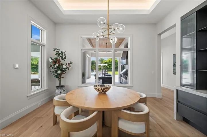 Dining room with a chandelier, light wood-type flooring, and baseboards