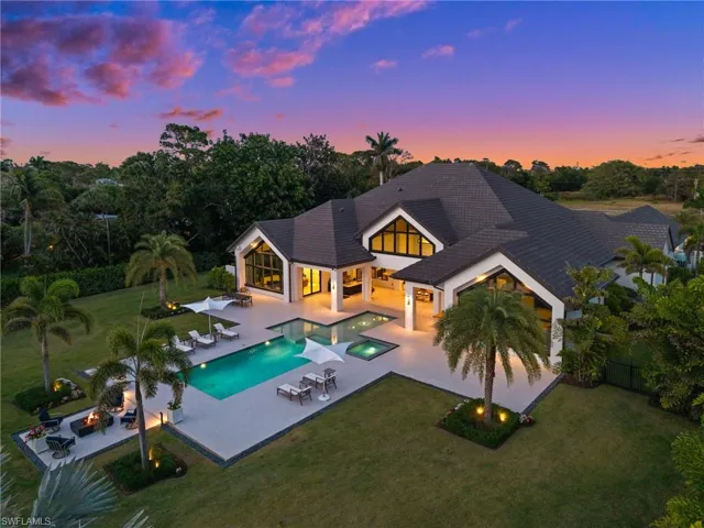 Pool at dusk featuring a patio area, an in-ground hot tub, an outdoor pool, and an outdoor living space