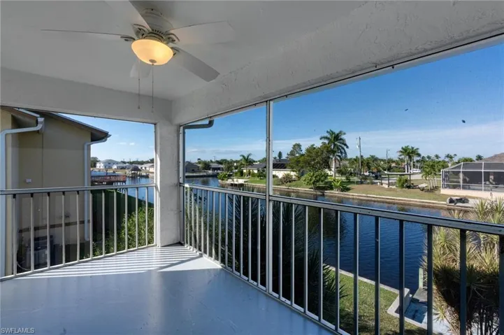Balcony with ceiling fan, a sunroom, and a water view