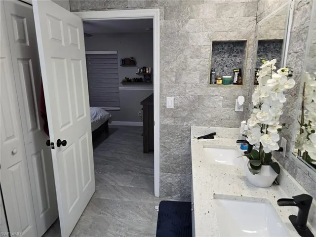 Ensuite bathroom with double vanity and tile walls