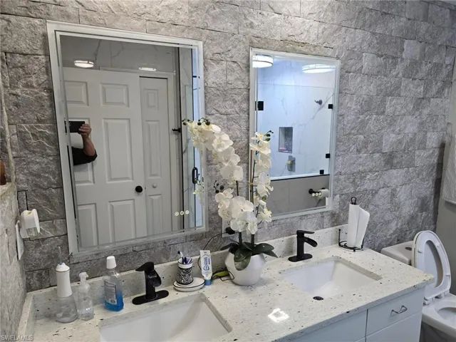 Bathroom with double vanity and toilet