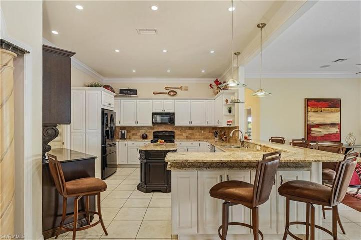 Kitchen has lots of cabinet and counter space, pantry closet, double oven, wine coolers, granite tops, tile back splash.
