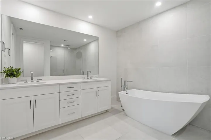 Dual vanity with undermount sinks, stone countertop, and contemporary fixtures