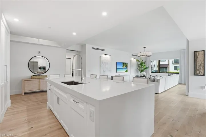 Expansive kitchen island with an integrated sink and gooseneck faucet