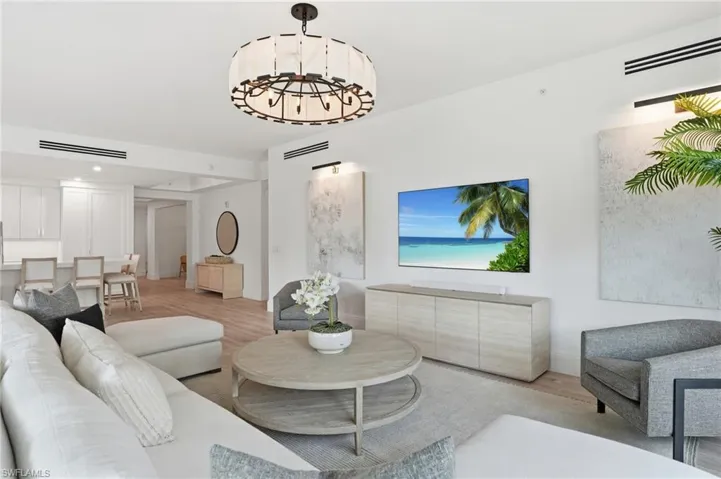 Spacious living area featuring high ceilings, wood-finish flooring, and recessed lighting