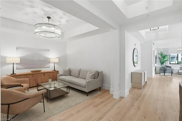 Recessed ceiling details, wood-finish flooring, and a contemporary chandelier