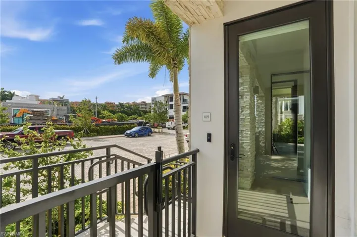 Modern balcony featuring a black aluminum railing system, glass panel infill, and direct access via a contemporary black-framed glass door