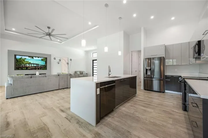 Kitchen with stainless steel appliances, modern cabinets, light wood-type flooring, light countertops, and recessed lighting
