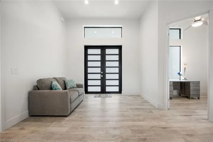 Entrance foyer with light wood finished floors, recessed lighting, and french doors