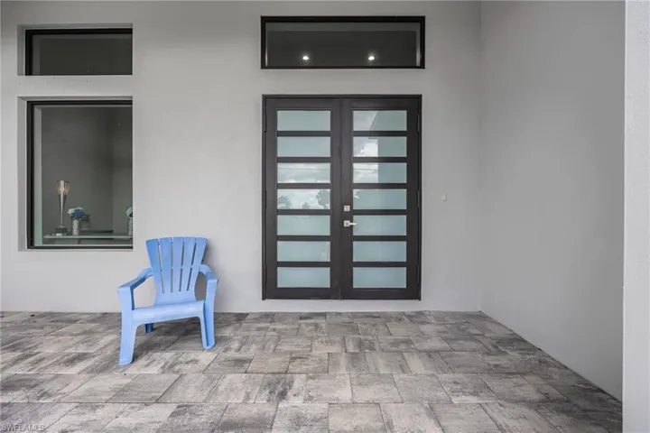 Entrance to property featuring french doors, stucco siding, and a patio