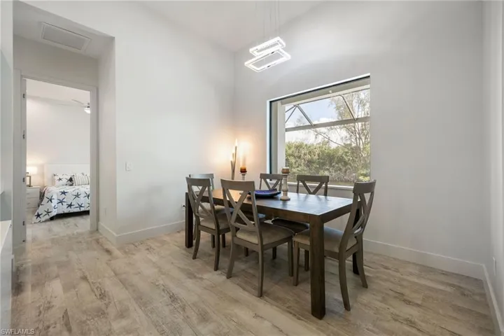 Dining space with light wood-style flooring and a high ceiling