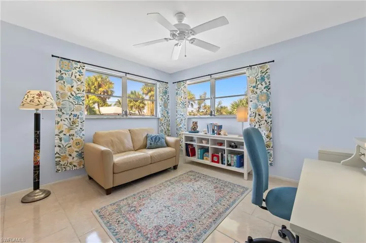 Office space with light tile patterned floors and ceiling fan