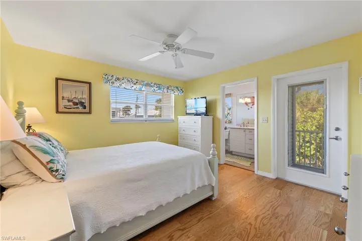 Bedroom featuring ceiling fan, access to outside, multiple windows, and light hardwood / wood-style floors
