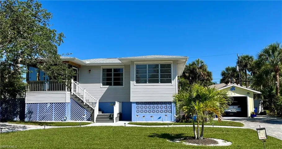 View of front of property with a garage and a front yard