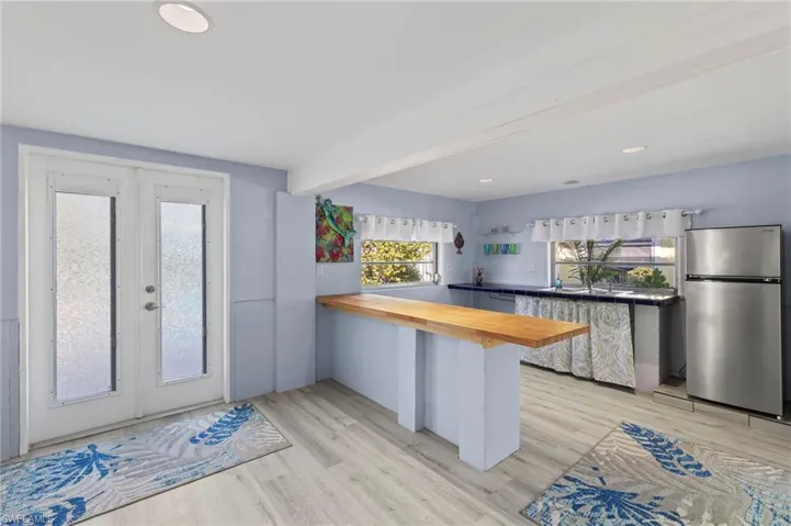 Kitchen featuring light hardwood / wood-style flooring, kitchen peninsula, and stainless steel refrigerator