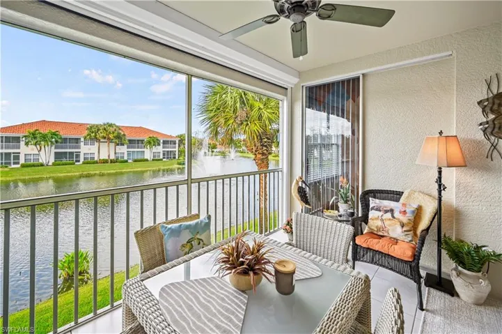 Sunroom / solarium featuring a water view and ceiling fan