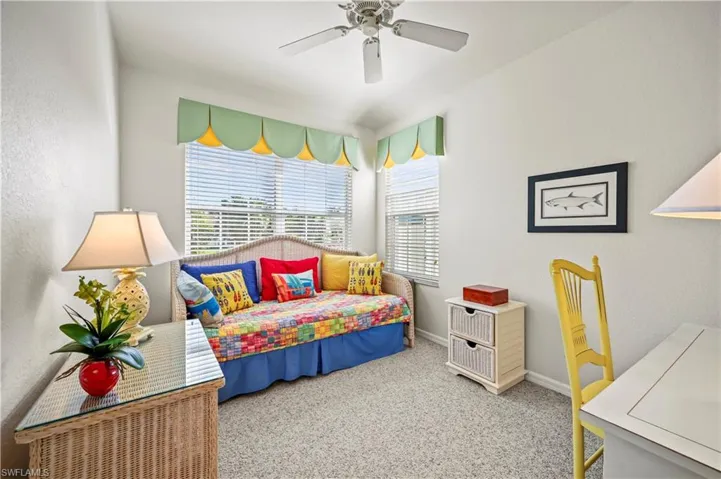 Carpeted bedroom featuring ceiling fan