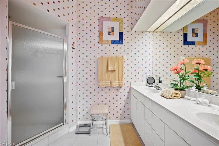 Bathroom with vanity, a shower with door, and tile patterned flooring