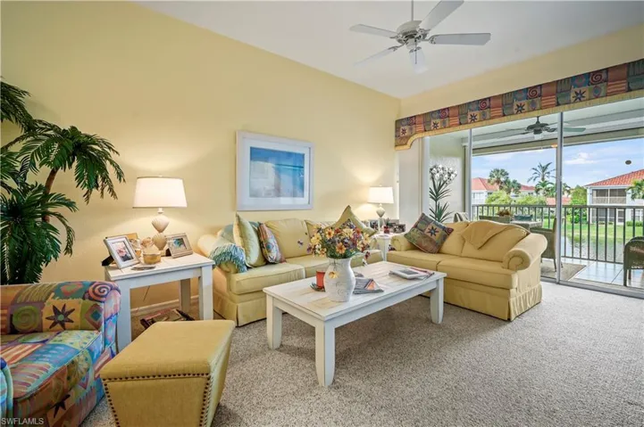 Carpeted living room featuring ceiling fan