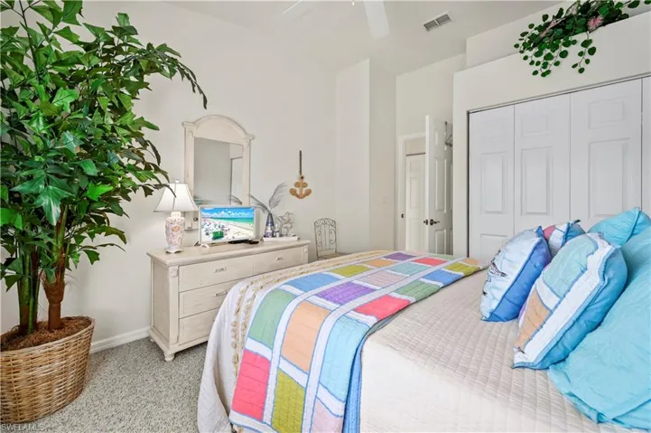Carpeted bedroom featuring ceiling fan and a closet