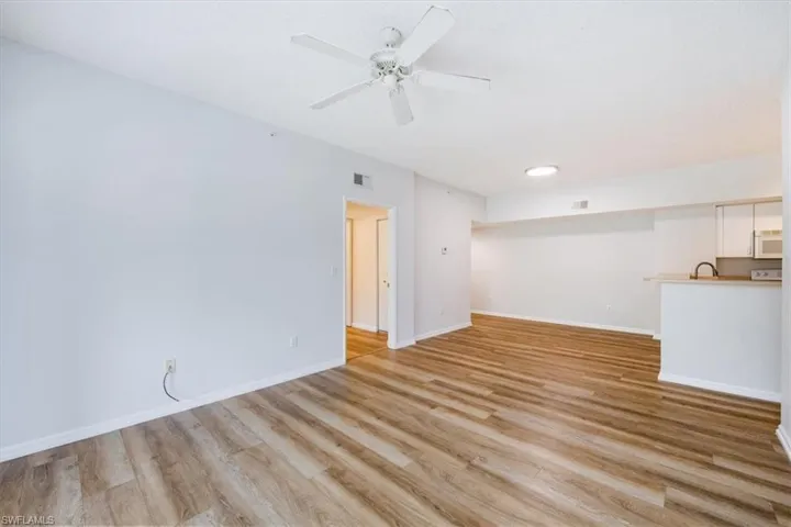 Empty room featuring ceiling fan, sink, and light wood-type flooring