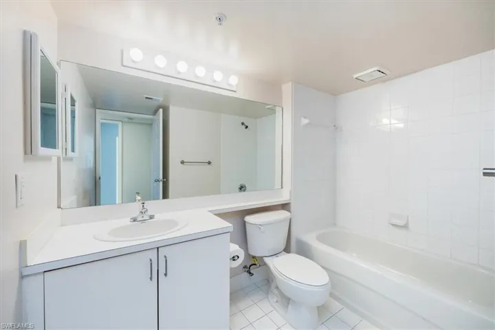 Master bathroom with tile patterned flooring, vanity, toilet, and tiled shower / bath