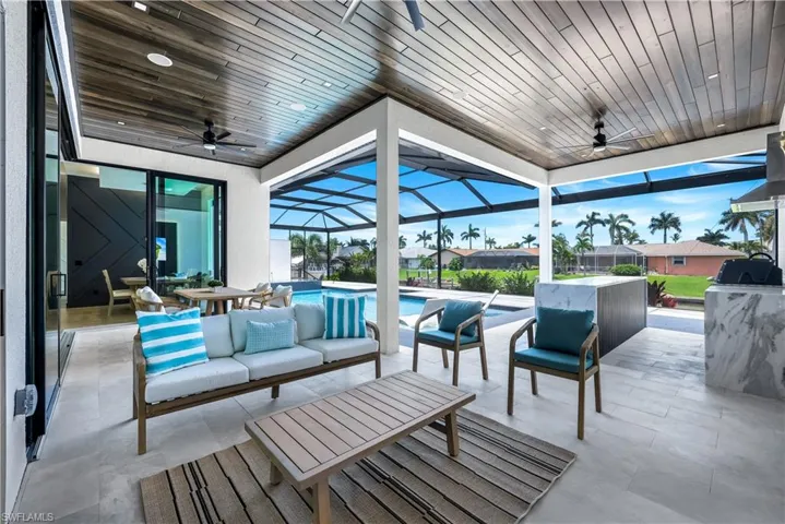 View of patio with ceiling fan, outdoor lounge area, an outdoor pool, and glass enclosure