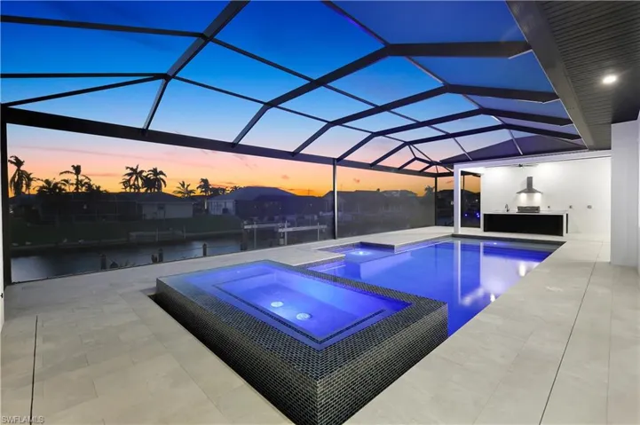 View of pool with a patio, exterior kitchen, a pool with connected hot tub, and a lanai