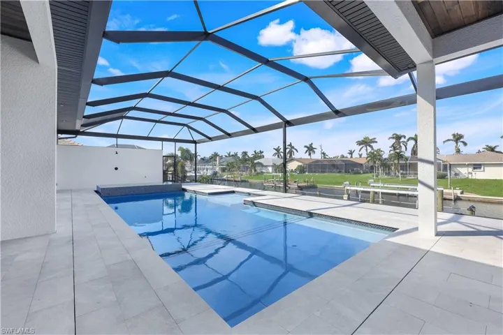 Outdoor pool featuring glass enclosure, a residential view, and a patio