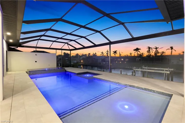 Pool with a water view, a lanai, an in ground hot tub, and a patio